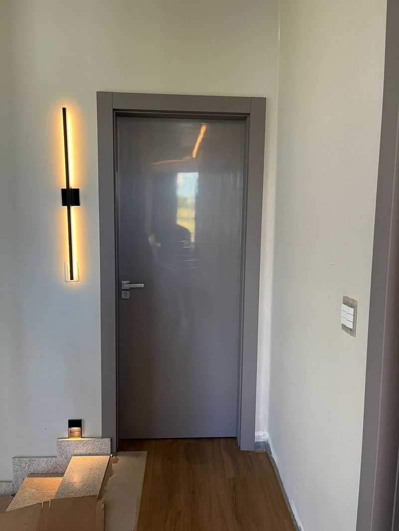 Porta WPC Lisa Cinza Portline — instalada com arandela decorativa